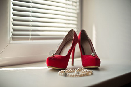 窗边的红色鞋和项链图片