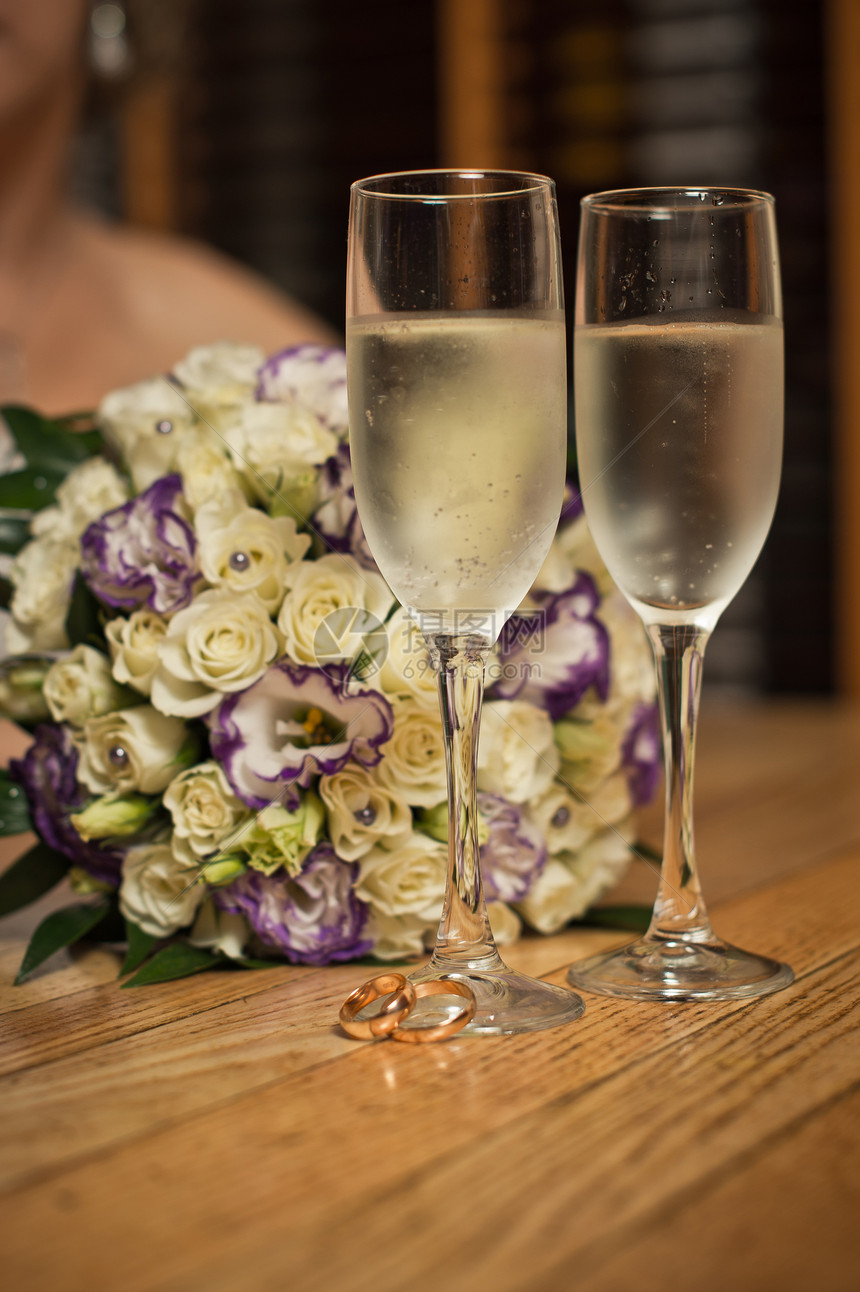 玻璃杯香槟和花束在桌子上图片