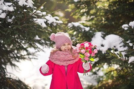 冬季森林中快乐的孩子带一束花快乐的女孩带一束康乃馨给妈92图片