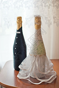 新郎的娘和新 喝着香槟的瓶子 衣服放在上图片