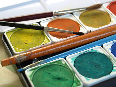 油漆工具配彩色调盘和刷子的油漆工具图片