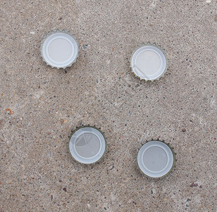 啤酒瓶盖水泥地板上的啤酒瓶盖图片