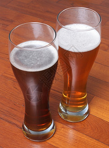 两杯德国黑白西化啤酒在地板上为浪漫约会背景图片