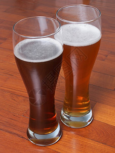 两杯德国黑白西化啤酒在地板上为浪漫约会背景图片