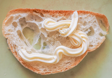 面包切片盘子里的一块面包配有蛋黄酱的图片