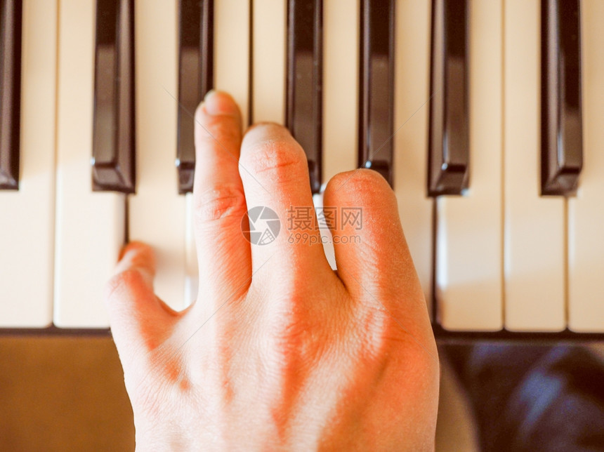 复古音乐键盘键复古外观的音乐键盘上的手玩细节图片