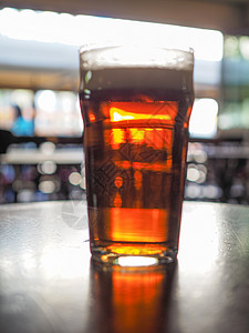 啤酒吧喝一品脱啤专注于和模糊的背景布基图片