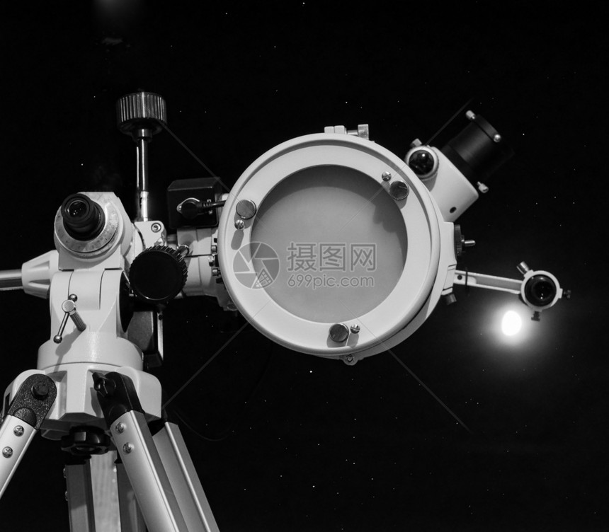 黑色和白天文望远镜与月亮一道在黑暗天空上与月亮相对有选择地聚焦于黑白望远镜图片