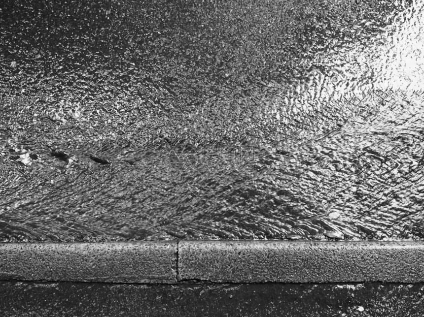 流下雨水在黑白大期间在街上流水在街道上图片