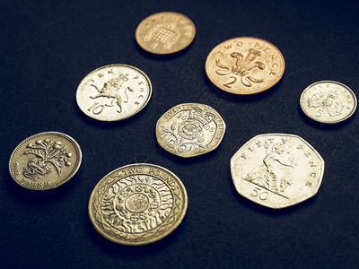 英国镑硬币货在黑暗背景下图片