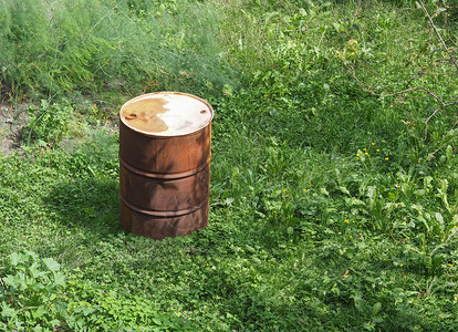生锈的油桶在草地上图片