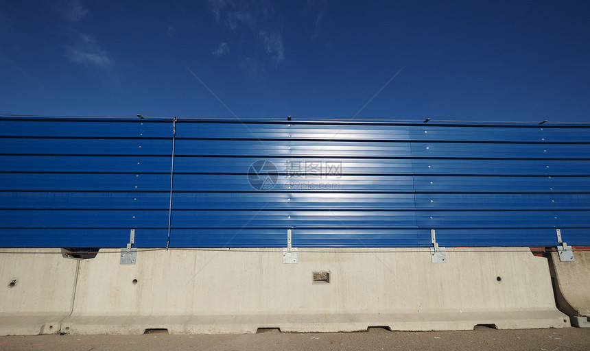 带有复制空间的混凝土屏障在蓝色天空和复制间上方有蓝色金属栅栏的混凝土屏障图片