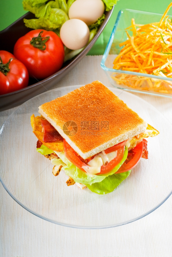 新鲜又美味的经典俱乐部三明治放在透玻璃碗盘上图片