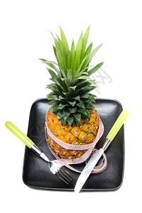 黑色盘子上的菠萝带子仪表刀片和叉子图片