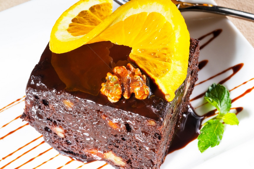 美味的巧克力和胡桃蛋糕上面和薄荷叶加一片奥兰斯图片
