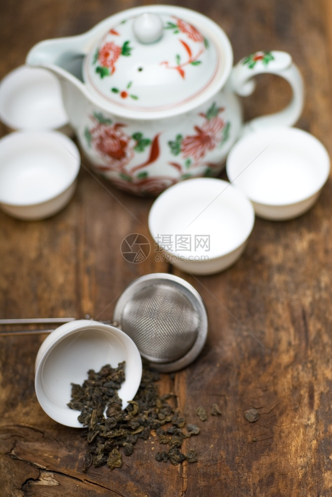 在旧木板上的背景配有教练员闭头杯子和茶壶图片