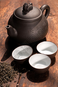 旧木板上的传统茶壶和杯子图片