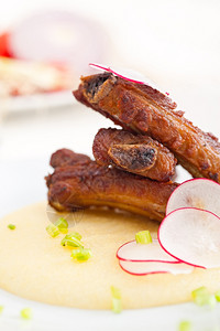 传统的意大利烤猪肉排在波伦塔床上吃玉米奶油图片