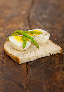 木板上含橄榄油的煮鸡蛋和面包片图片