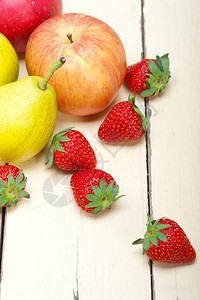 新鲜水果苹梨和白木桌上的草莓图片