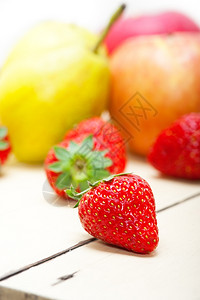 新鲜水果苹梨和白木桌上的草莓背景图片