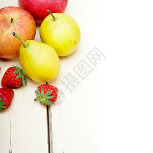 新鲜水果苹梨和白木桌上的草莓背景图片