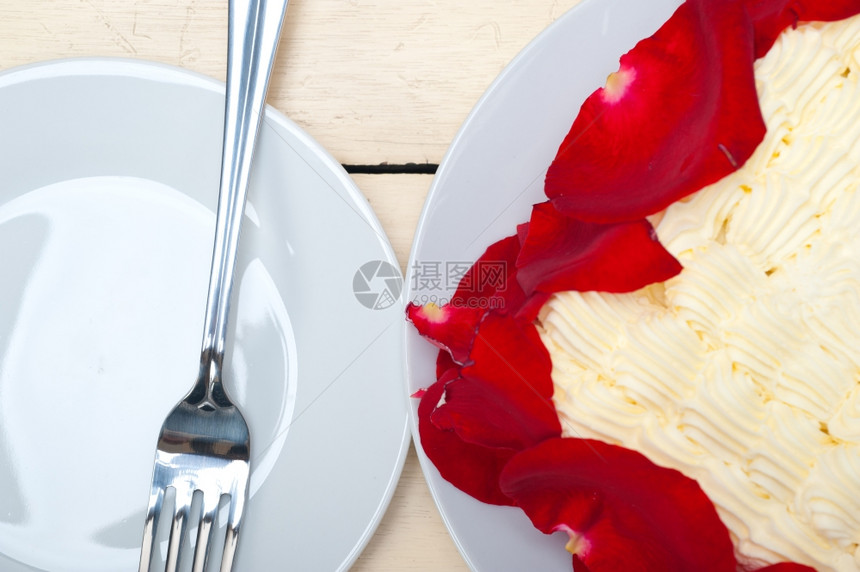 带红玫瑰花瓣的奶油芒果蛋糕图片
