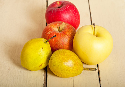白木桌上的新鲜水果苹和梨子背景图片