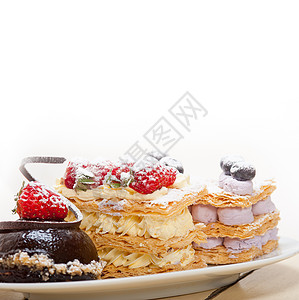 选择新鲜奶油拿破仑和巧克力慕斯蛋糕甜板背景图片