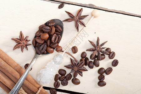 银汤匙上的咖啡糖和香料在白木生锈的桌子上图片
