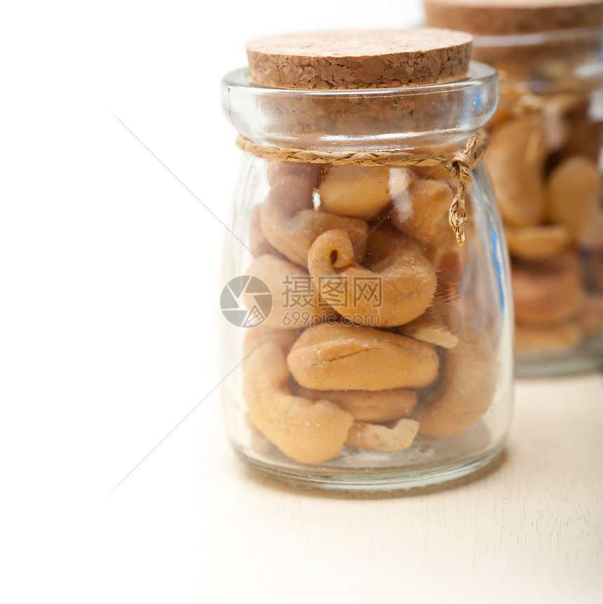 一个玻璃罐上的腰果在白锈木板上的玻璃罐子图片