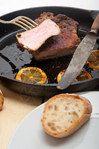 用加柠檬和香料调味的铁椰子烤熟猪肉图片