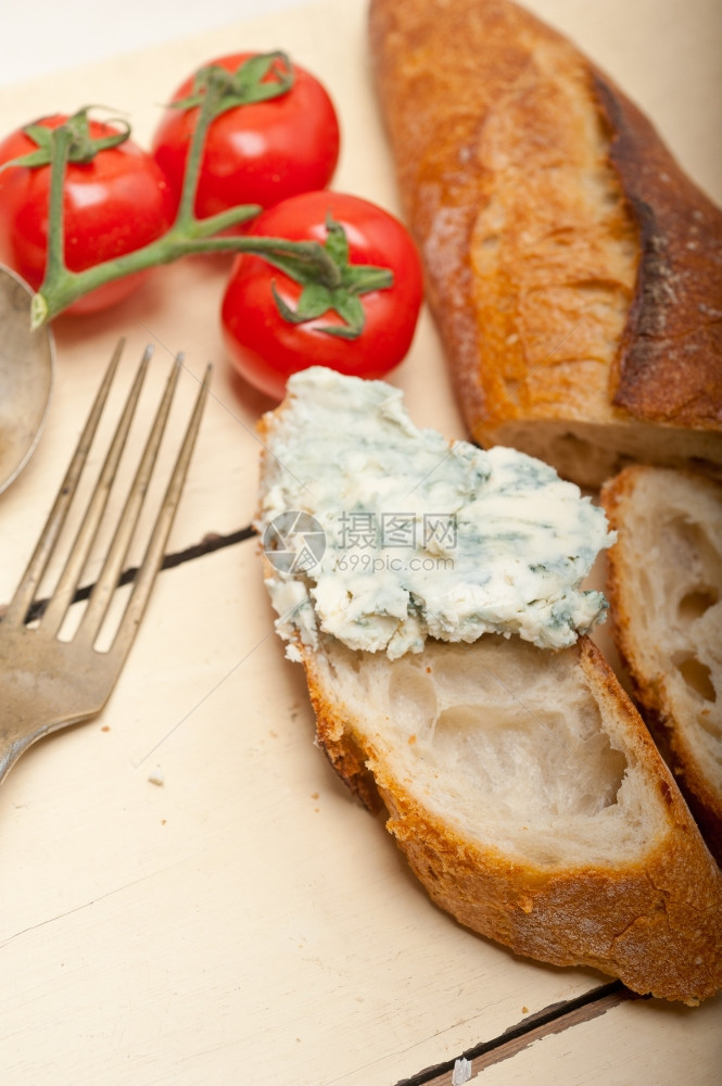 新鲜蓝芝士分散在法国面包上边有樱桃西红柿图片
