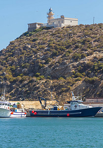 西班牙马扎龙镇的灯塔和小型捕鱼港口图片