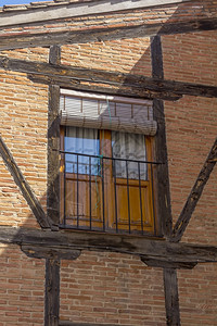 以木梁和砖块装有头的旧房子窗玻璃上图片