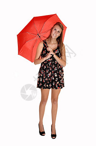 一个穿黑领裙和高跟鞋的漂亮少年在工作室里穿红色伞状的白背景图片