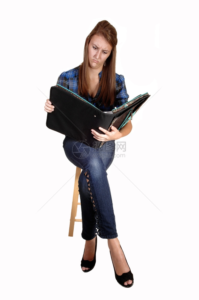 坐在椅子上穿牛仔裤着蓝色鸡胸衣手上拿着笔记本白底黑图片