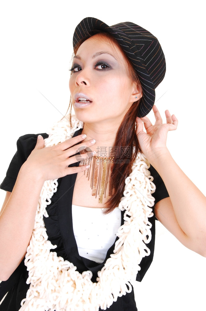 一个漂亮的女人戴着帽子和围巾着她的领带穿黑色夹克站在工作室里寻找白背景图片