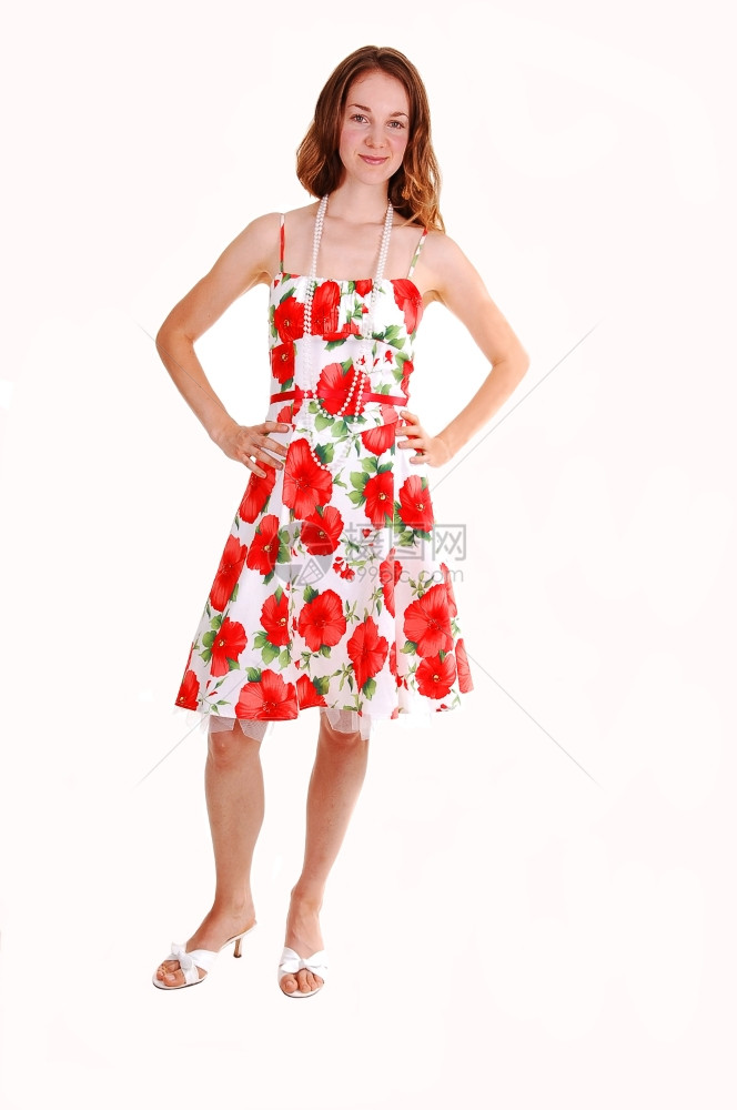 年轻可爱的姑娘穿着多彩的裙子棕色头发看着镜高跟鞋站在工作室白背景图片