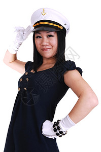 一个海军一个年轻的亚洲美女身着水手制服白套水帽站在工作室敬礼背景
