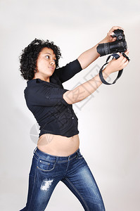 一位漂亮的西班牙裔女试图拍摄自己身穿黑色上衣和牛仔裤身穿浅灰色图片