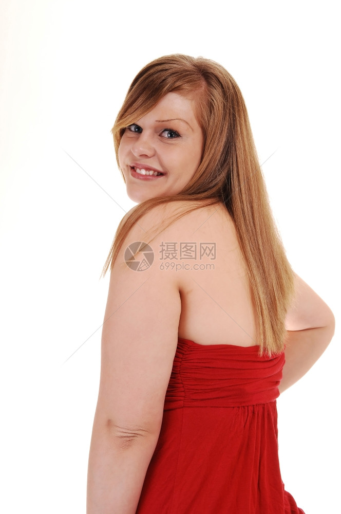 一个穿红裙子的年轻女人站在镜头前看着她的肩膀寻找白背景图片