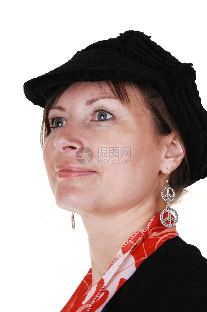 一个穿着黑色毛衣的中年妇女戴着黑帽子和红色围巾站在工作室里微笑着画一张白色背景的肖像图片