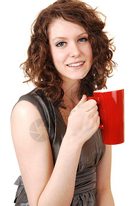 一个可爱的年轻女人手里拿着一个红咖啡杯白底黑高清图片