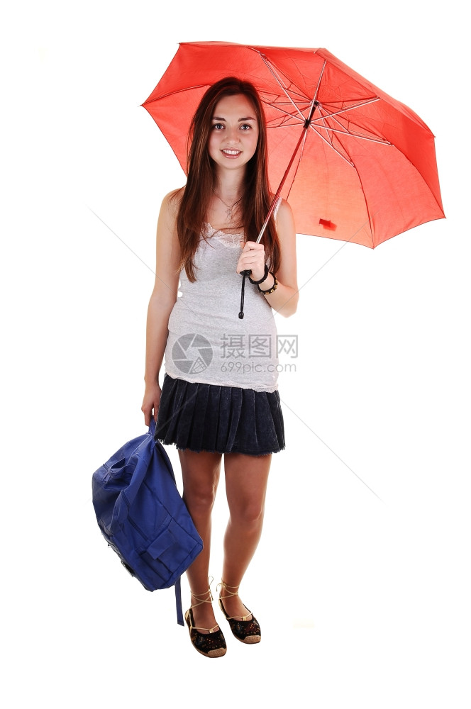 一个穿短裙的漂亮少女手里拿着一个蓝色背包肩膀上还有一把开着的伞站在工作室里寻找白背景图片