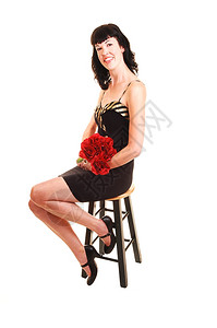 一位身着黑裙子的高个女青年坐在椅子上身着红玫瑰图片