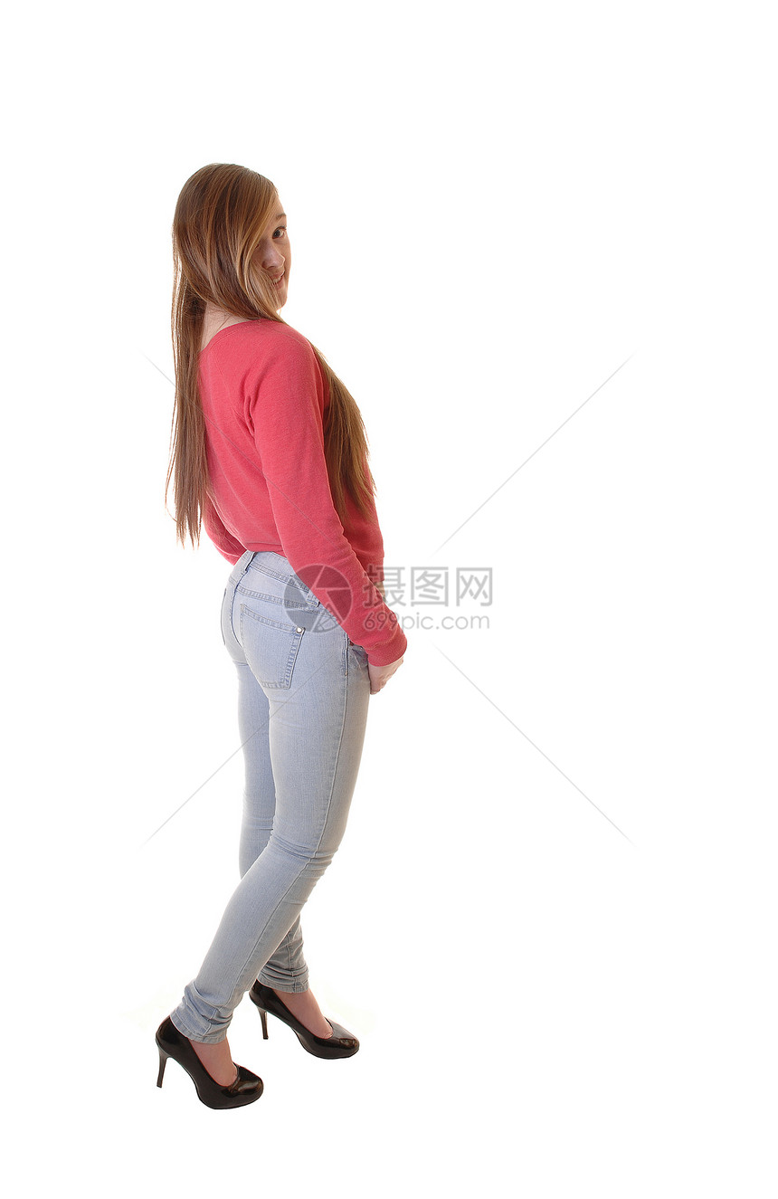 一个穿牛仔裤红色毛衣着高跟鞋的少年站在工作室里长着黑发白背景图片