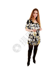 一个三十多岁的美女长金发站在工作室穿着裙子和黑靴白色背景图片