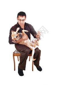 一只西班牙男在大腿上骑着小狗和他最好的朋友玩耍坐在椅子上做白背景图片