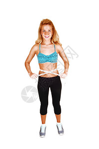 一个可爱的瘦女人在她锻炼后测量的胃部长卷发金白种背景图片